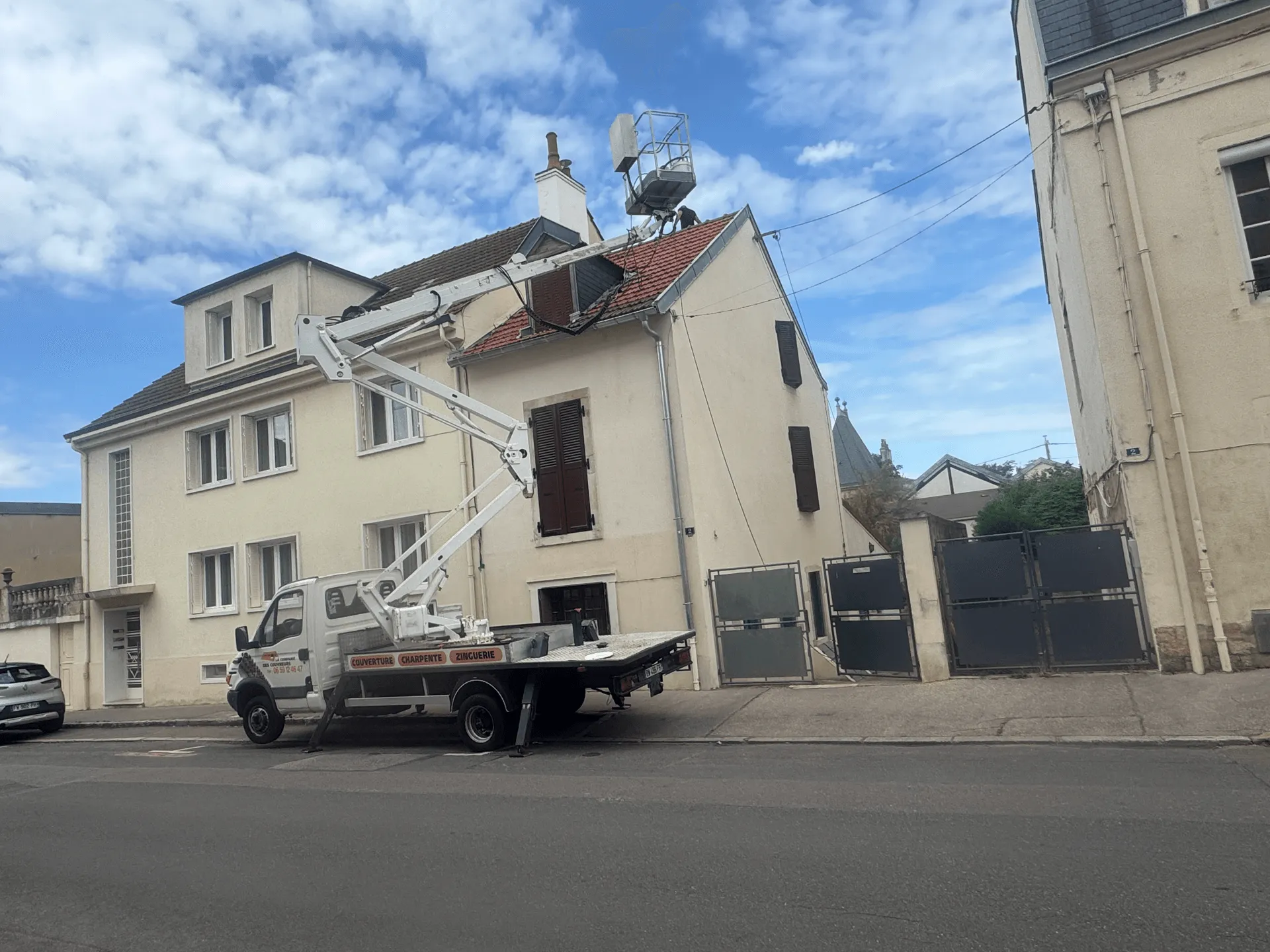 Camion et nacelle déployée au-dessus de la toiture d’un immeuble à Dijon