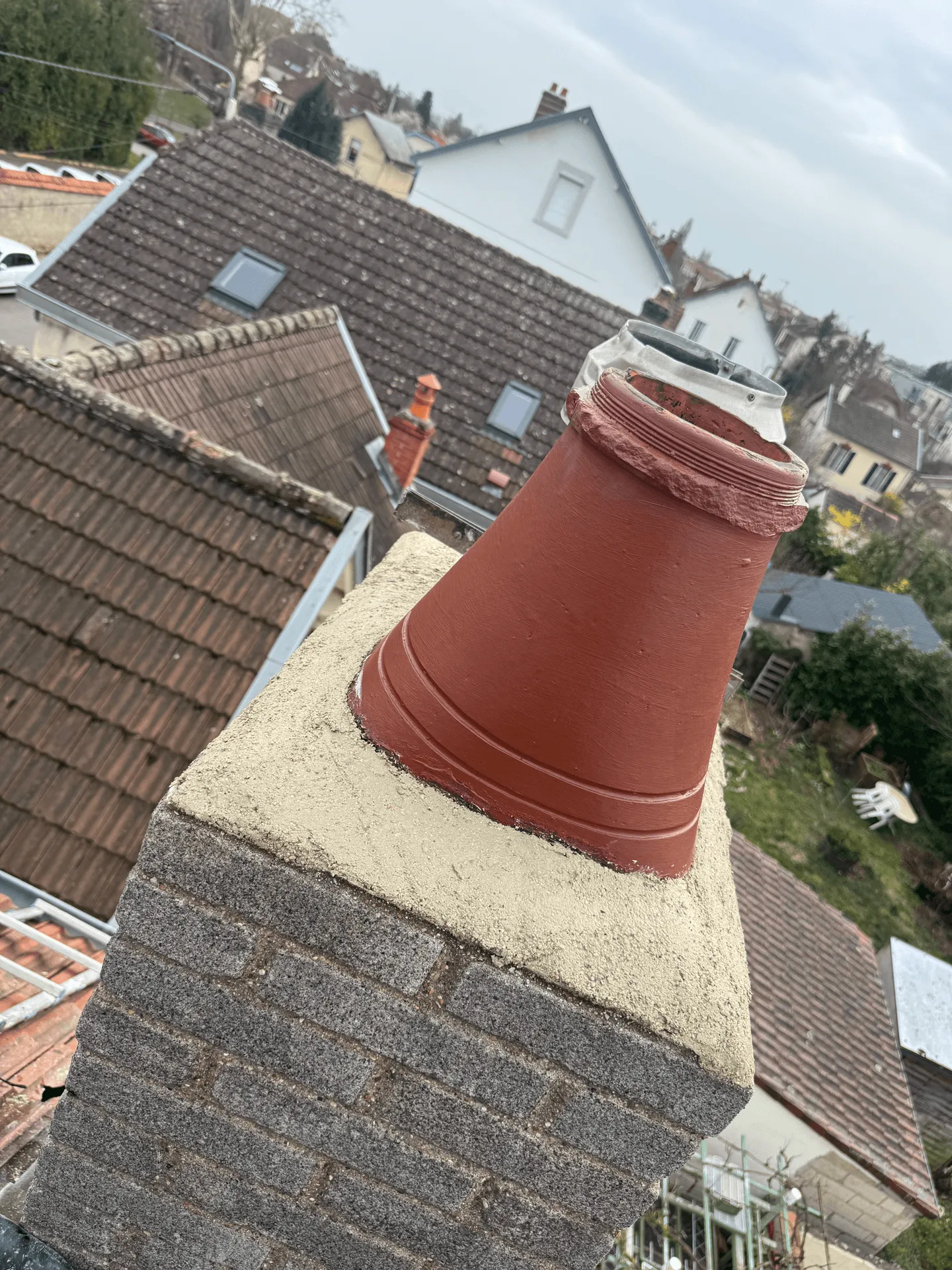 Souche de cheminée maçonnée et sortie de conduit au-dessus des toits