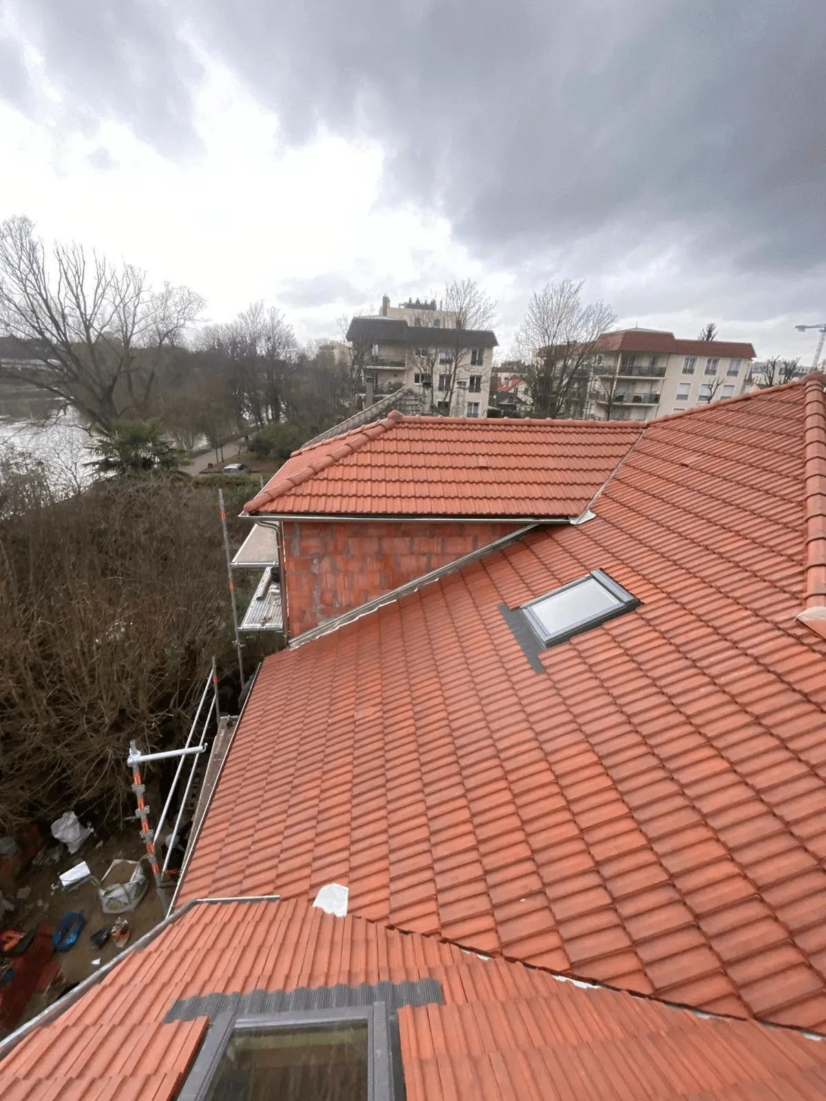 Toiture en tuiles rouges avec fenêtres de toit, vue depuis le chantier